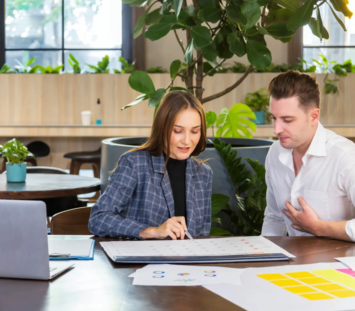 Two people discussing work at a table.