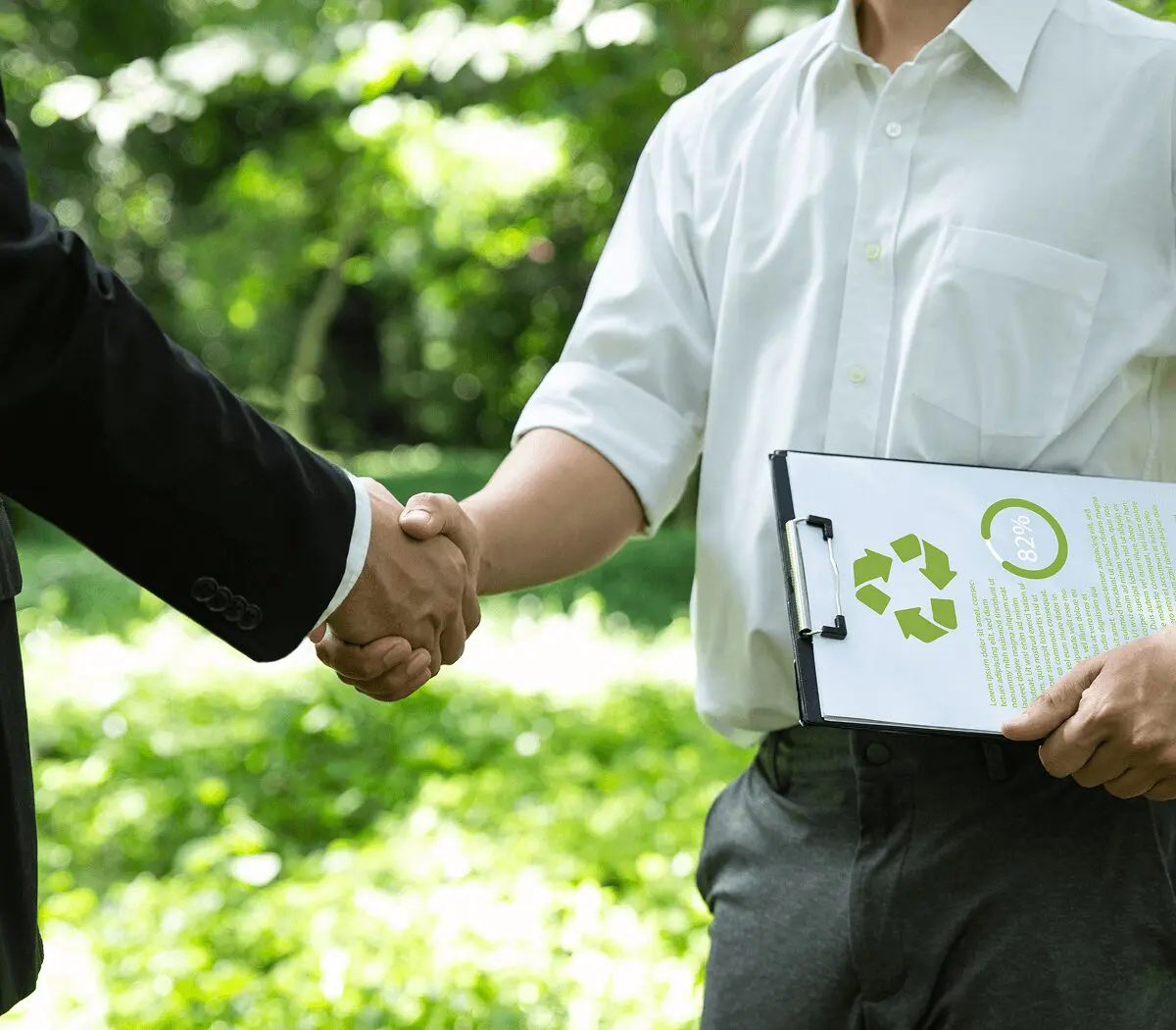 Handshake between businessmen in green environment.